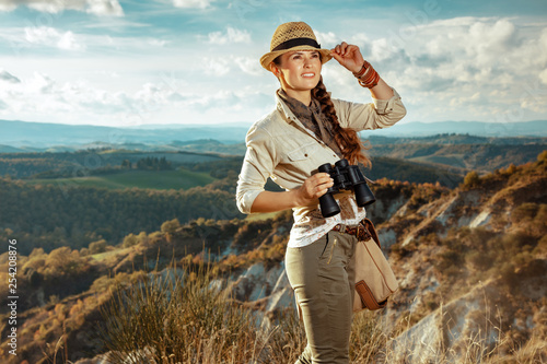 solo traveller woman with binoculars looking into the distance