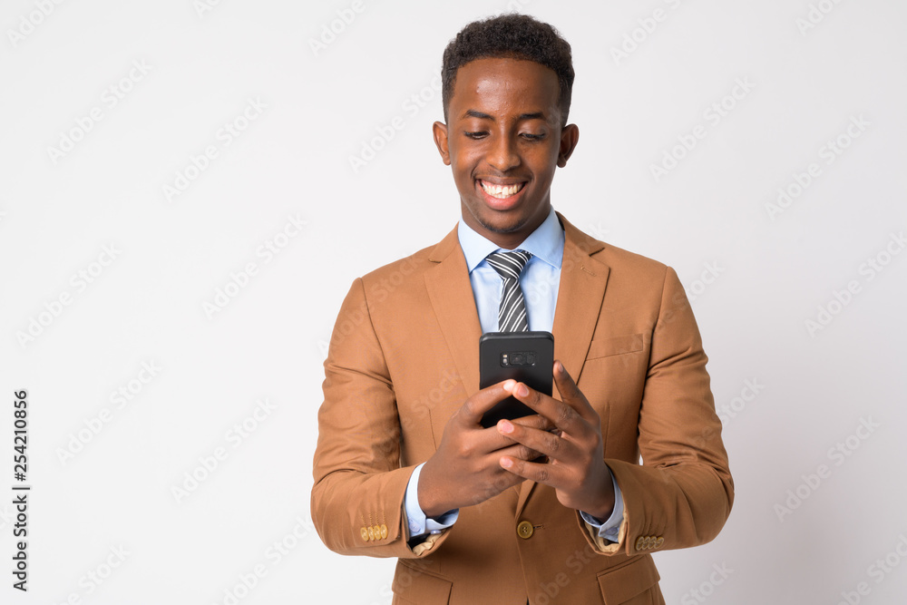 Portrait of young happy African businessman using phone Portrait of young happy African businessman using phone