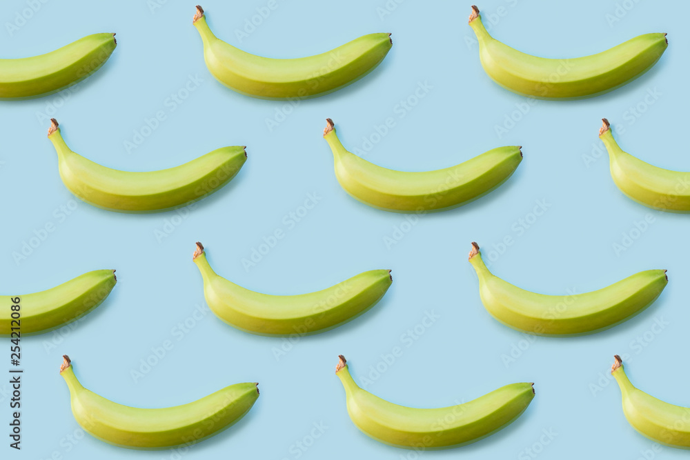 Banana pattern on blue background, top view. Concept of simple and healthy raw food, flat lay style shot