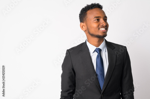 Portrait of happy young handsome African businessman thinking