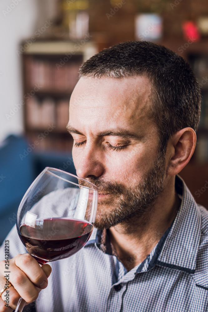 Man tasting a glass of red wine. Selective focus. Man tasting a glass of red wine. Selective focus.