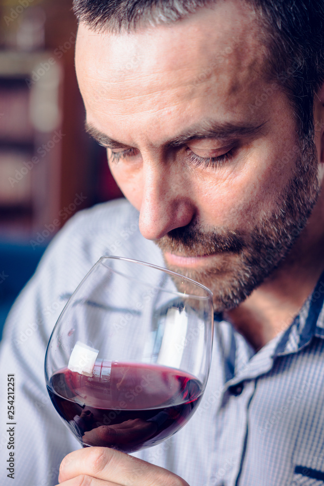 Man tasting a glass of red wine. Selective focus. Man tasting a glass of red wine. Selective focus.