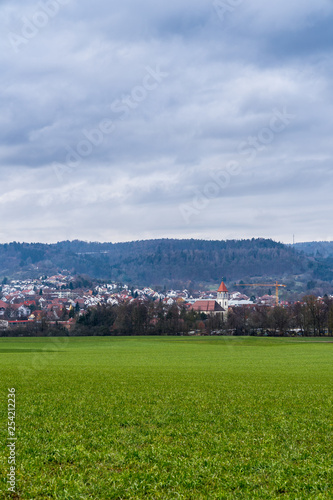 Germany, Rudersberg houses and church of town behind green meadow