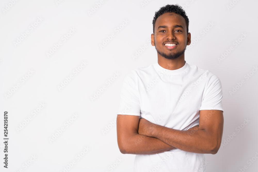 Portrait of happy young handsome African man smiling with arms crossed Portrait of happy young handsome African man smiling with arms crossed