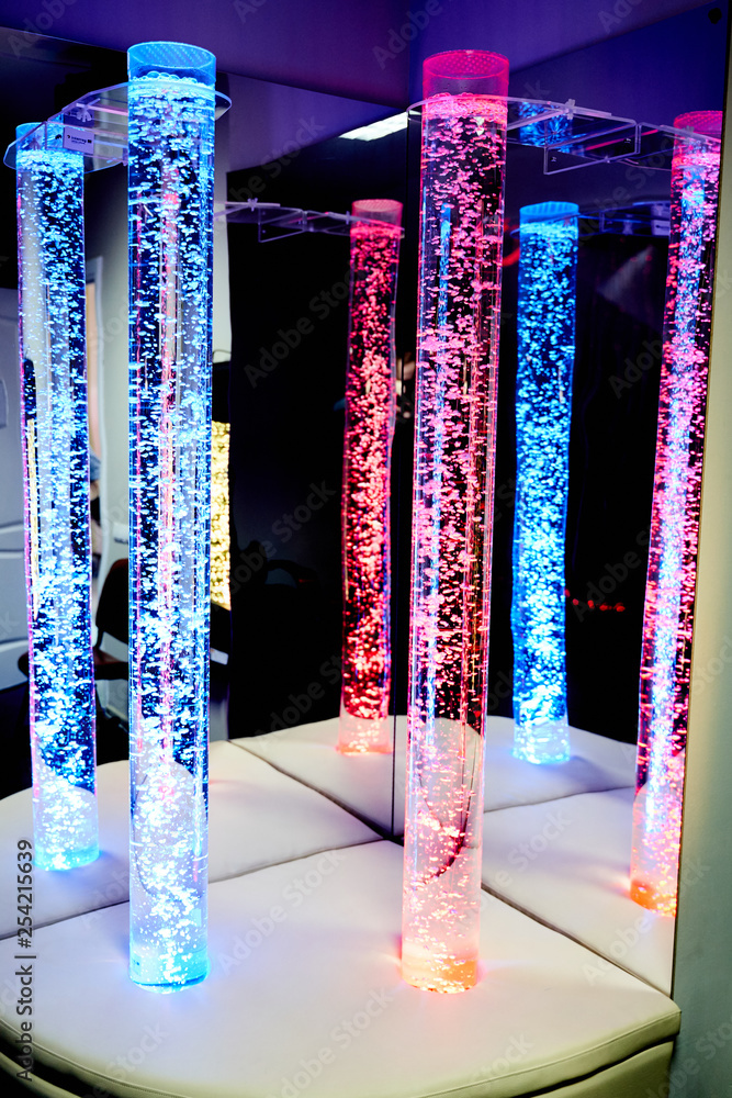 Colorful snoezelen room with bubble tubes and disco lights on Craiyon