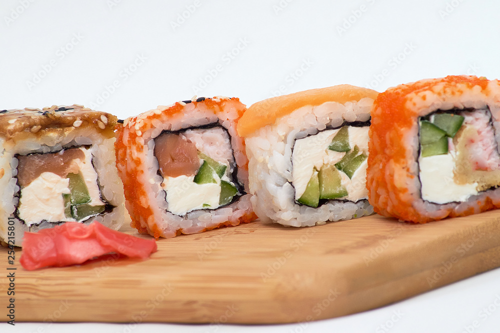 set of sushi rolls on wooden Board on white background. set of sushi rolls on wooden Board on white background.