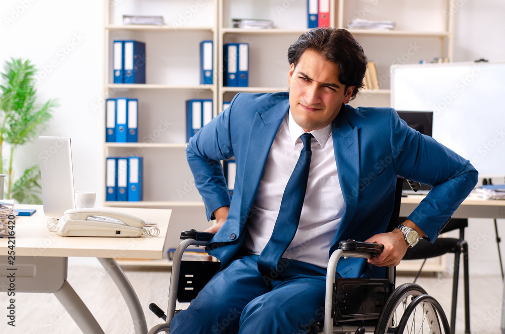 Male employee in wheelchair working at the office Male employee in wheelchair working at the office