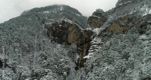 Aerial footage mountain waterfall in winter