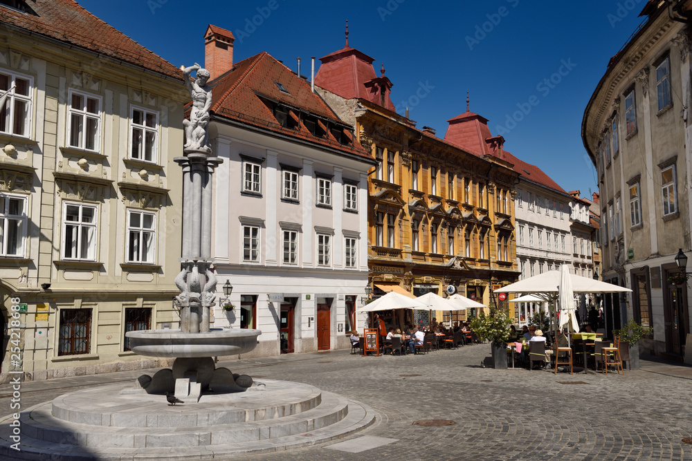 Hercules fountain next to the historic Sticna Mansion monestary house 1630 at Old Square cobblestone street in Old town of Ljubljana Slovenia