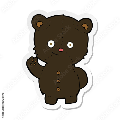 sticker of a cartoon waving black bear cub