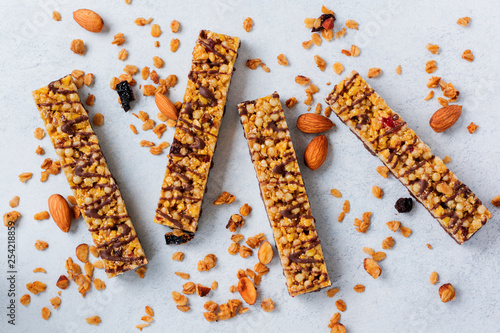 Cereal granola bar with nuts, fruits and berries on a whhite stone table. Granola bar. Healthy snack. Top view. photo