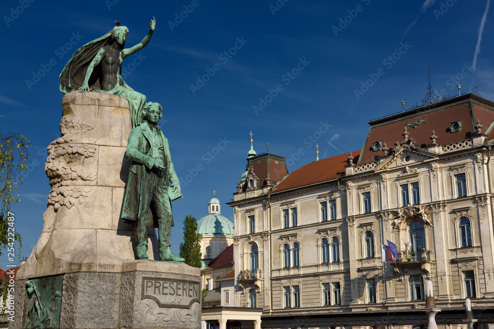 Obraz premium Bronze sculpture of national poet Preseren Monument with Muse and historic Kresija building with government offices and dome of Ljubljana Cathedral