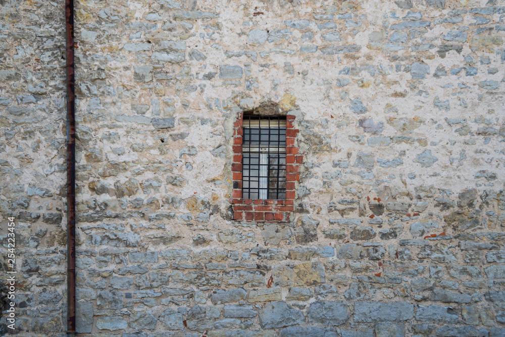 Stadtmauer mit vergittertem Fenster