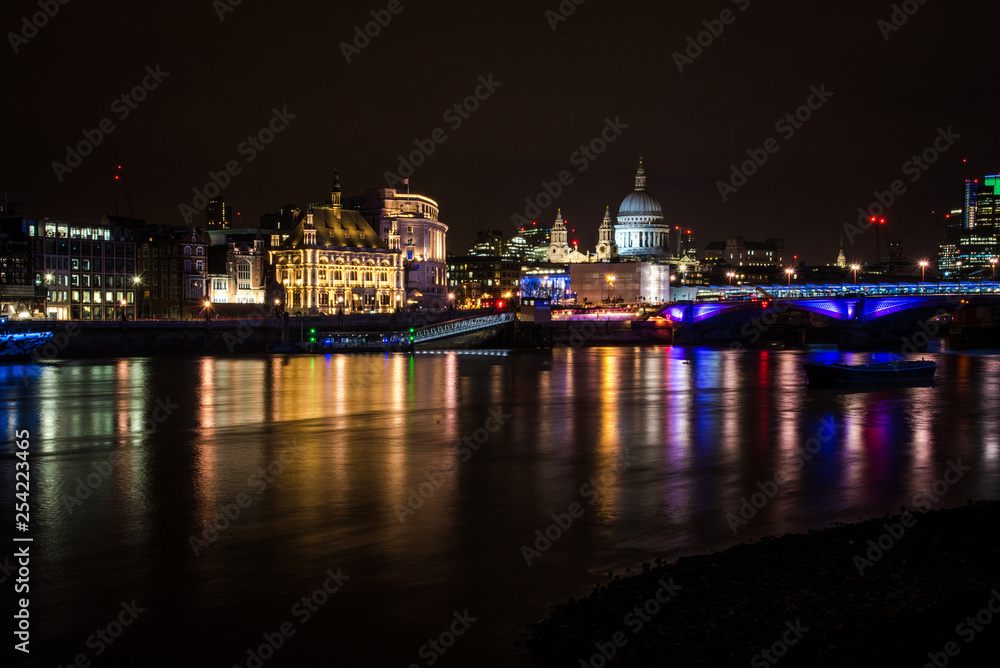 London's skyline and Thames river at night