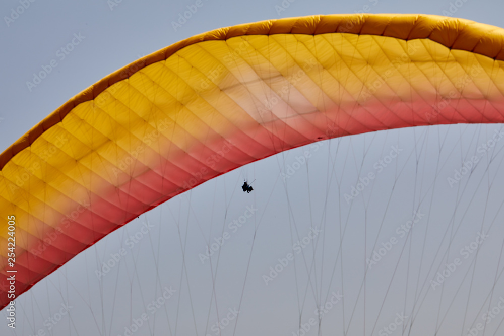 Flying on a paraglider. Beautiful view with mountains and colorful paragliders. Extreme vacation travel