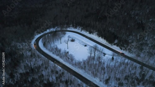 drone video at dusk in the mountains with cars driving around a hairpin photo