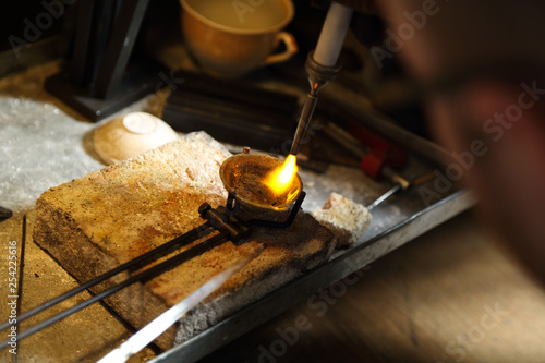 Jeweler melting precious metal with hydrogen burner