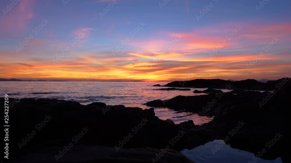 Slider shot of stunning blue-orange sunset over coastal reefs on Mediterranean sea Slider shot of stunning blue-orange sunset over coastal reefs on Mediterranean sea