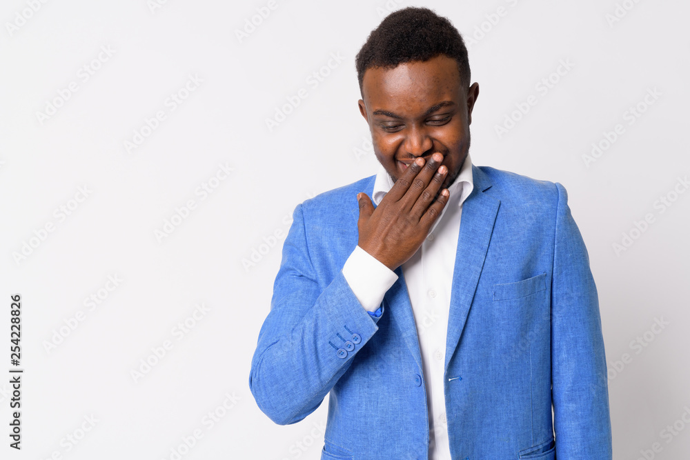 Portrait of happy young African businessman laughing and covering mouth Portrait of happy young African businessman laughing and covering mouth