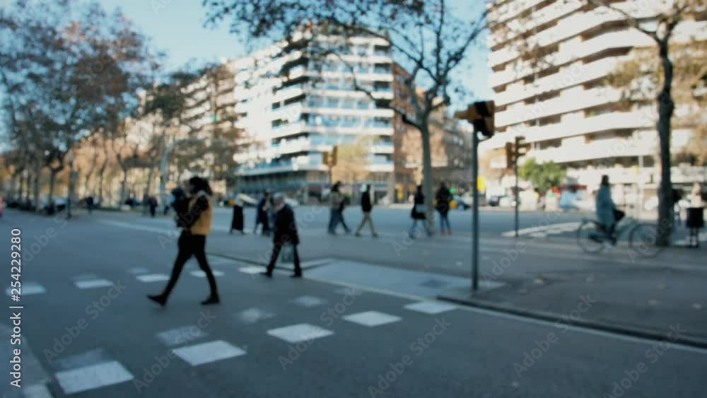 A busy street of a big city, with blurred anonymized people crossing and cars moving. A busy street of a big city, with blurred anonymized people crossing and cars moving.
