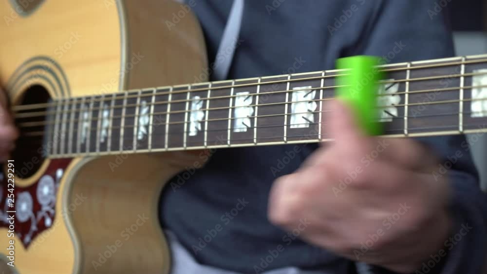 Guitar player playing slides on an acoustic guitar with a lighter Guitar player playing slides on an acoustic guitar with a lighter