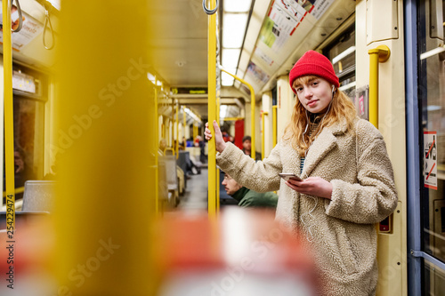 junge Frau, Mädchen, Teenager, mit Smartphone, fährt mit der U-Bahn  photo