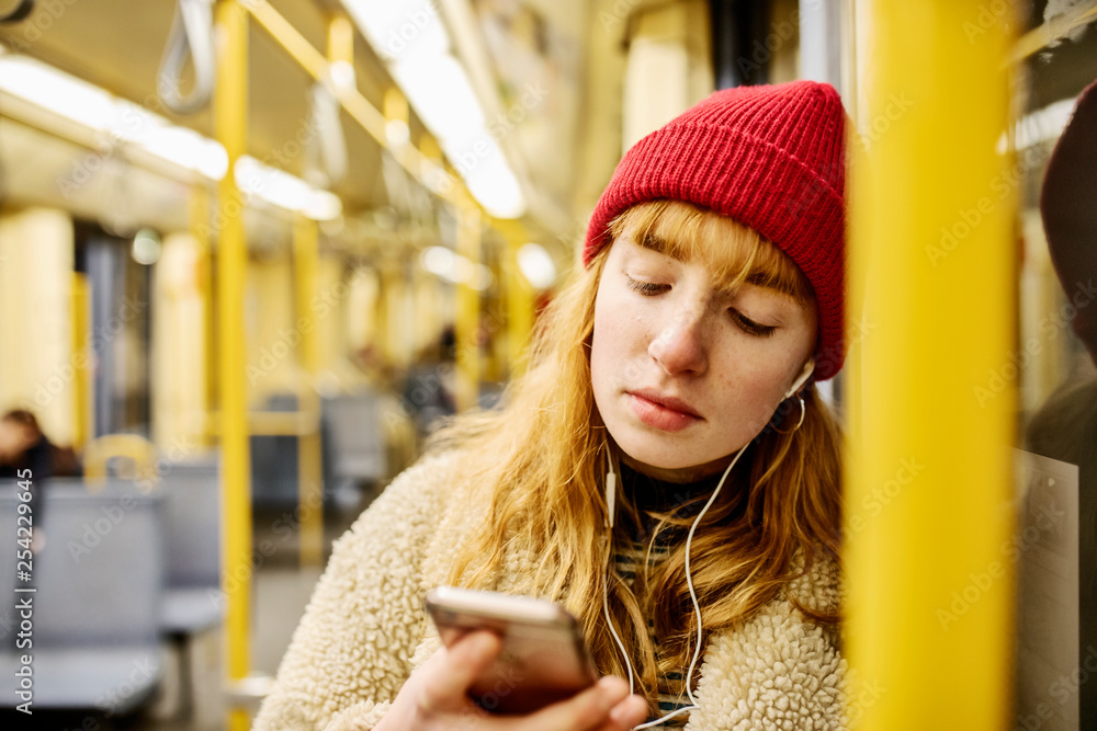 junge Frau, Mädchen, Teenager, mit Smartphone, fährt mit der U-Bahn junge Frau, Mädchen, Teenager, mit Smartphone, fährt mit der U-Bahn