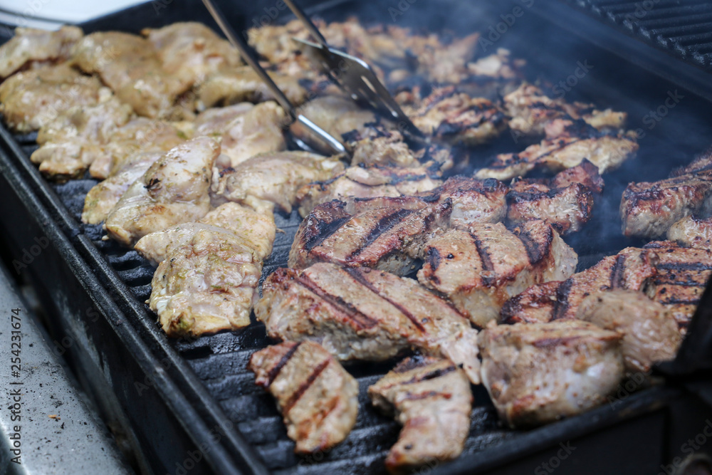 Sizzling, delicious grilled steak and chicken hot off the barbecue at an outdoor garden party