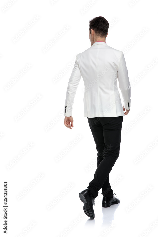 back view of elegant businessman walking and looking to side back view of elegant businessman walking and looking to side