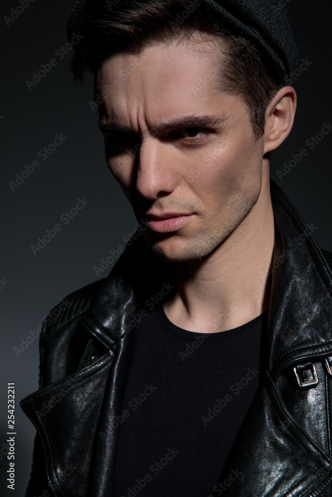 portrait of a dramatic man wearing leather jacket and hat portrait of a dramatic man wearing leather jacket and hat