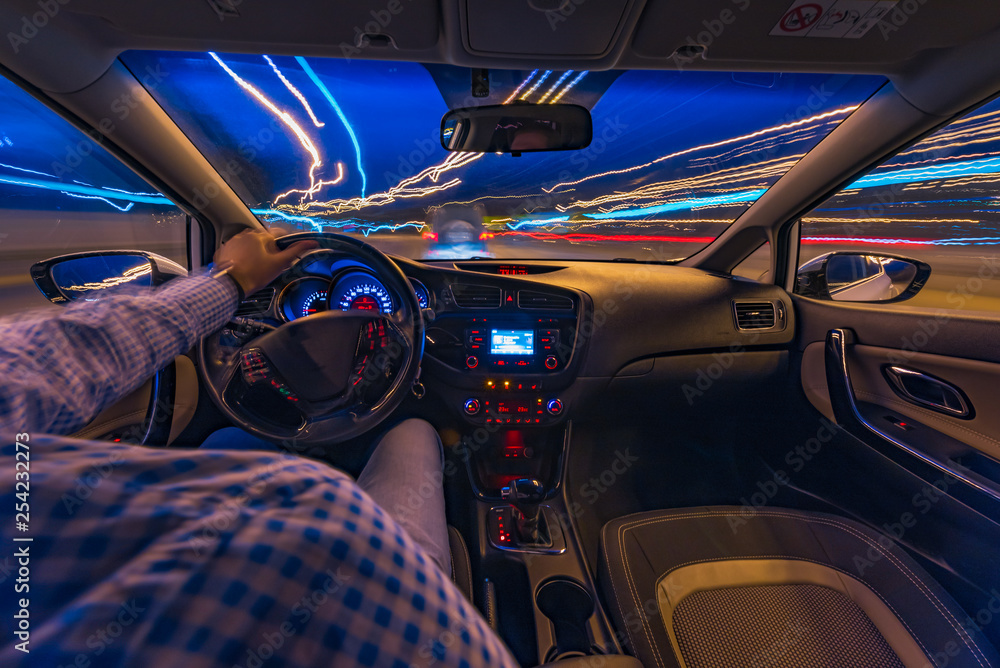 driving a car at night at high speed view from the car. blurred city. one  hand driving Stock Photo | Adobe Stock