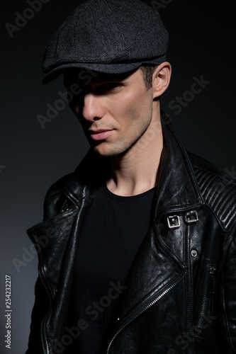 man in leather jacket wearing hat to cover his eyes