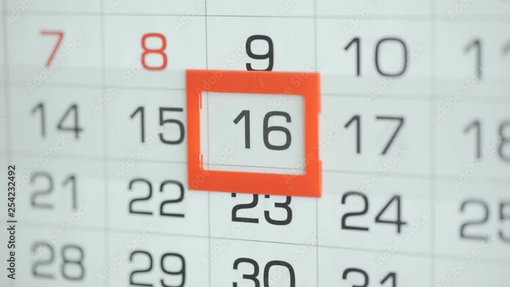 Woman's hand in office changes date at wall calendar. Changes 15 to 16 Woman's hand in office changes date at wall calendar. Changes 15 to 16