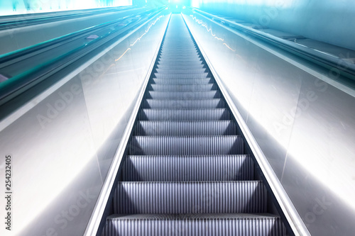 View escalator stairs rise to the top of the blue white shine light