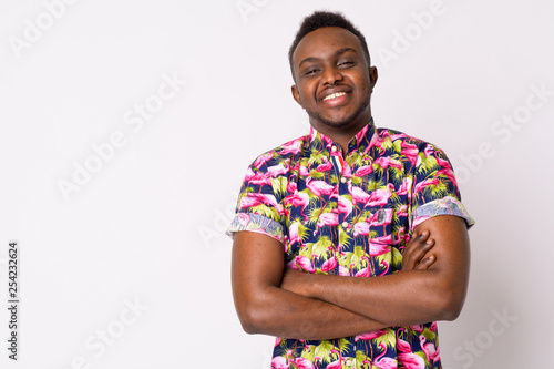 Portrait of happy young African tourist man smiling with arms crossed photo