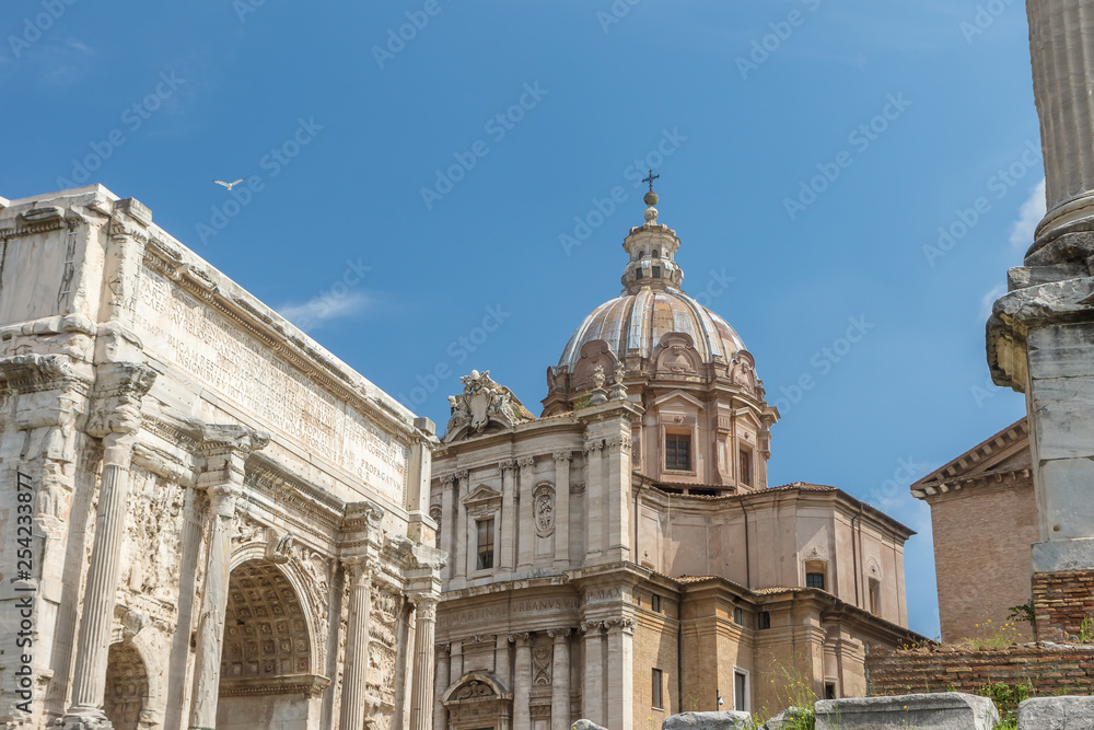 Ancial Arch of Septimius Severus in Forum Romanum. Church of Santi Luca e Martina is in the background. Rome. Italy.