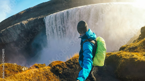 Iceland - Man taking selfie with the waterfall.