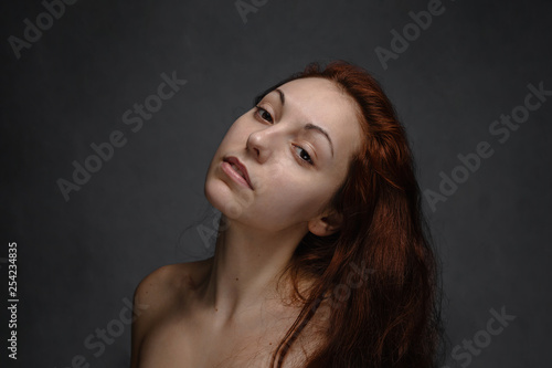 Portrait of beautiful woman with loose hair posing on a camera. Black background.
