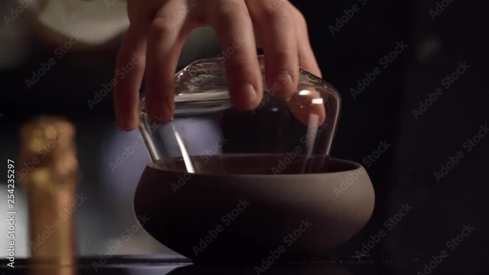 A bartender is garnishing the cocktail glass creating crusta around the rim of the crystal glassware. A bartender is garnishing the cocktail glass creating crusta around the rim of the crystal glassware.