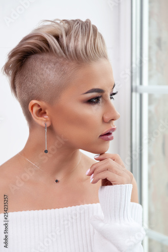 Cuadro en lienzo Closeup sexy blonde model with bright make-up, bare shoulders and short hair with shaved temples in modern round silver jewelry earrings and necklace