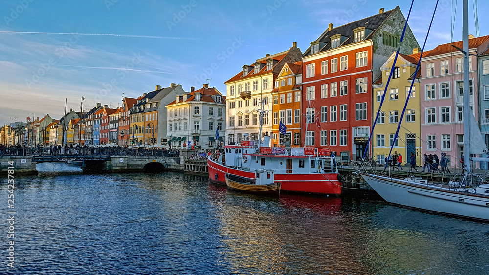 Nyhavn waterfront, canal and entertainment district with colorful houses, buildings, ships, yachts and boats in Old Town of Copenhagen, Denmark