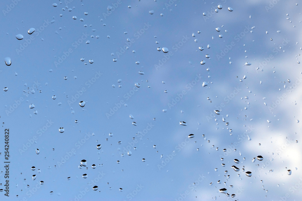 Sky view through window with rain drops on blue blurred backgroud. - Image Sky view through window with rain drops on blue blurred backgroud. - Image
