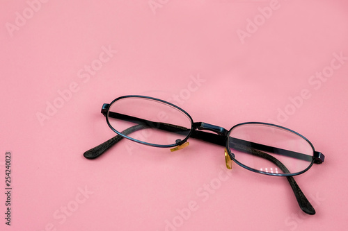 Glasses lying on pink background. Concept of eyesight