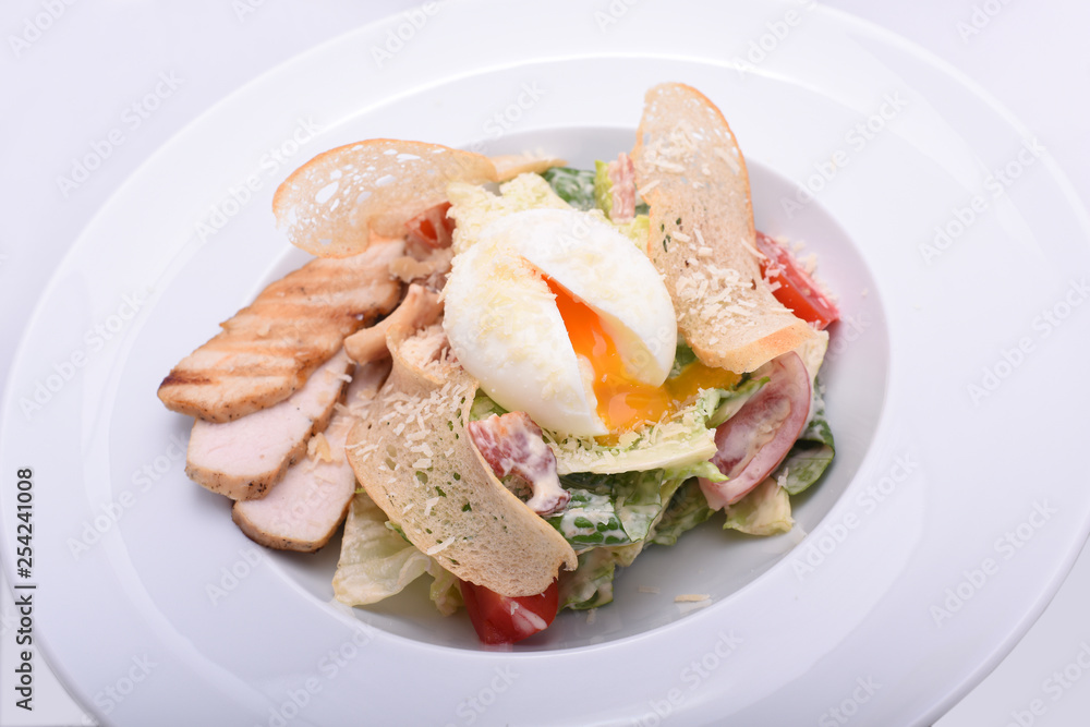 Healthy and tasty salad from fresh vegetables, with thin toasts and poached egg. View from above. On a white background Healthy and tasty salad from fresh vegetables, with thin toasts and poached egg. View from above. On a white background