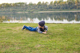 Children and childhood concept - Smiling little boy laying on the grass