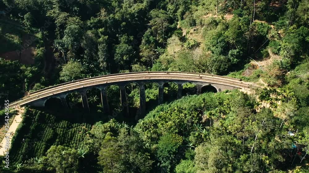 Aerial of famous nine arch bridge in Ella, Sri Lanka with blue train Aerial of famous nine arch bridge in Ella, Sri Lanka with blue train
