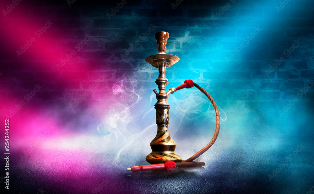 Hookah with smoke on the background of an empty brick wall, wet asphalt and colored neon light, blurry lights of the night city, bokeh Hookah with smoke on the background of an empty brick wall, wet asphalt and colored neon light, blurry lights of the night city, bokeh