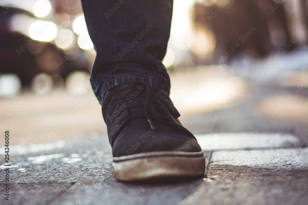 Closeup photo of the legs of men in black sneakers against the background of the track Closeup photo of the legs of men in black sneakers against the background of the track