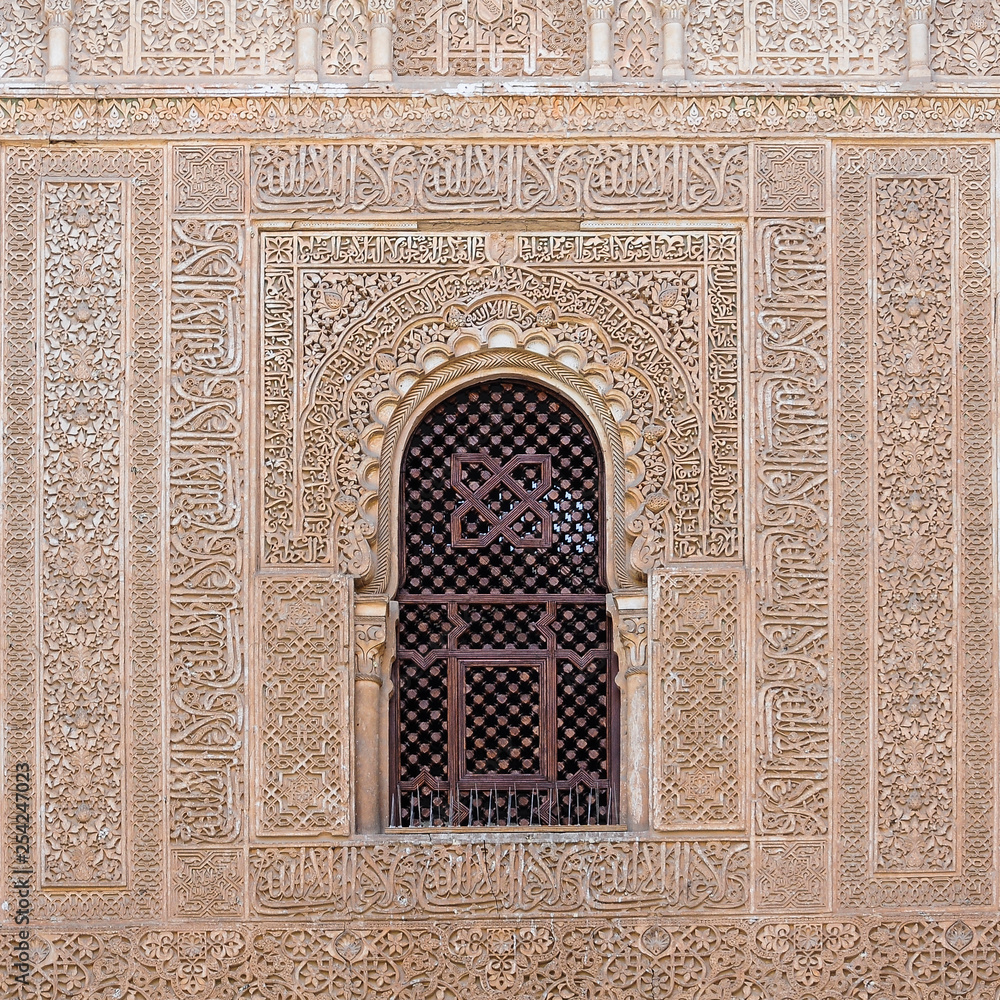 Detail of an arched window decorated with Moorish motifs in the Nasrid Palaces of the Alhambra. Granada, Spain