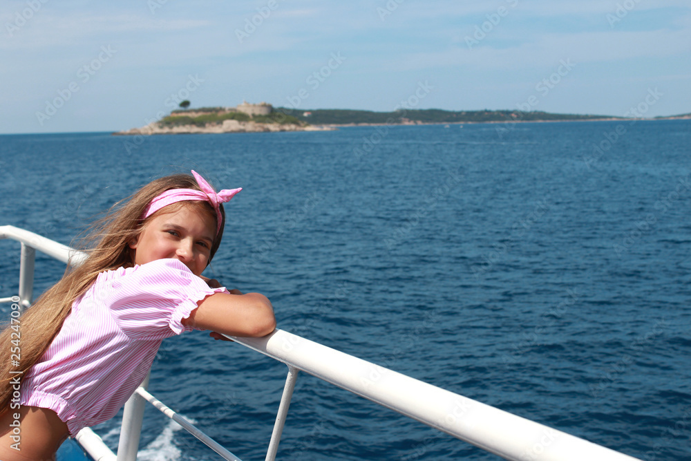 happy little girl sailing in a boat smiling at the sea on summer cruise Stock Photo Adobe Stock